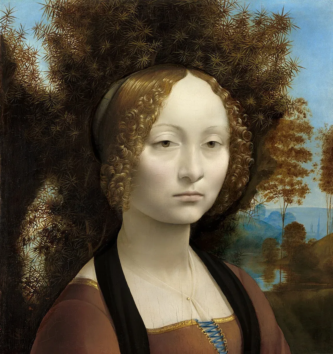 Portrait of a pale young woman with tight curls in front of a dark juniper bush and a misty landscape