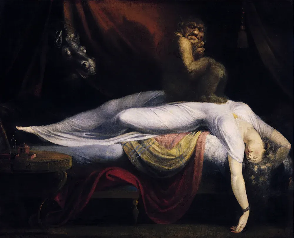 A sleeping woman in a white gown lies across a bed while a goblin crouches on her chest and a horse’s head looks in