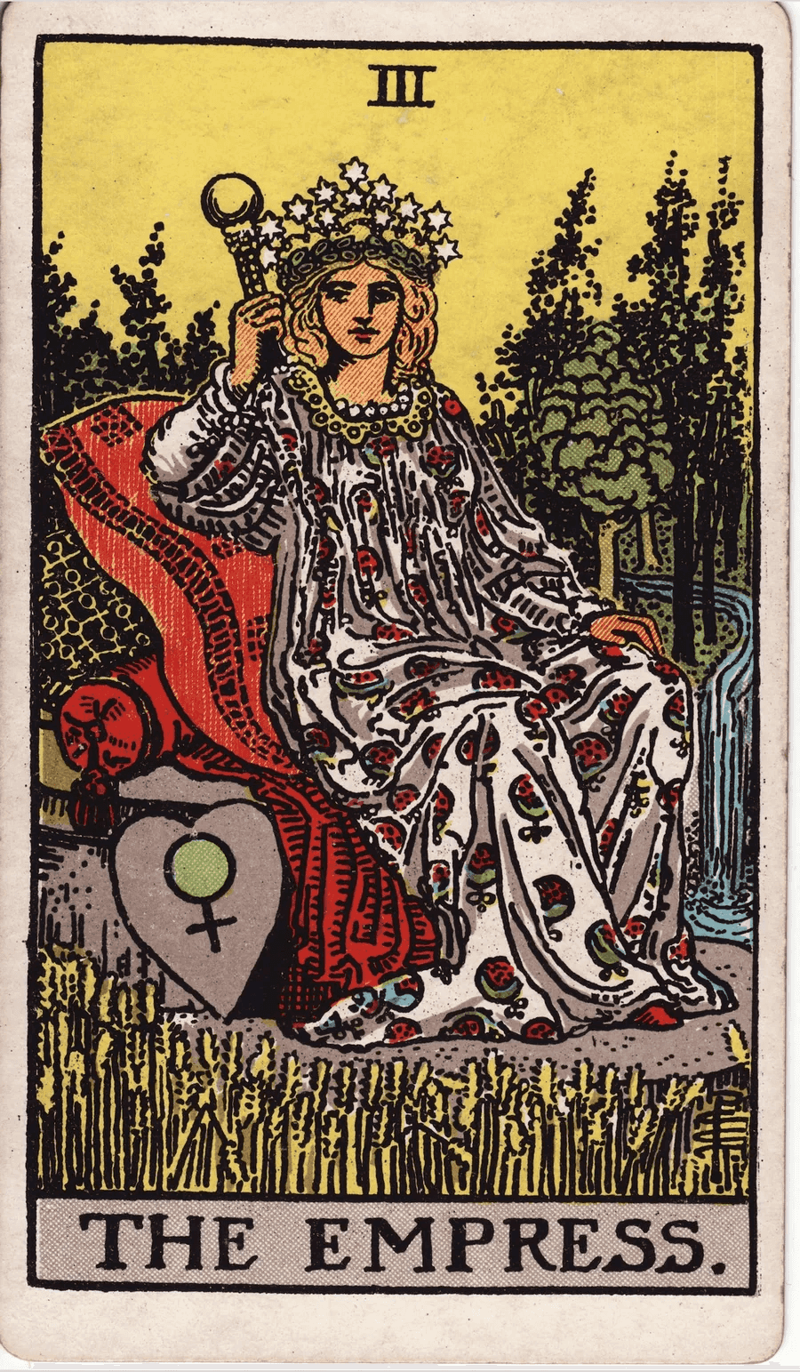 The Empress card from the 1909 Rider-Waite-Smith deck: a crowned woman in a pomegranate-patterned robe sits on cushions in a field of ripe wheat, with a forest and a waterfall behind her