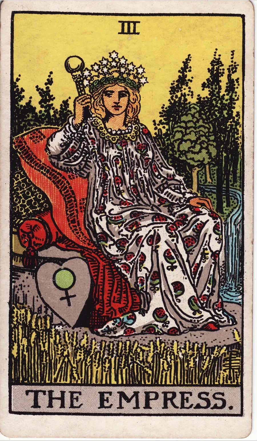 A crowned woman in a gown patterned with pomegranates sits on cushions in a field of ripe wheat, with a forest and waterfall behind her