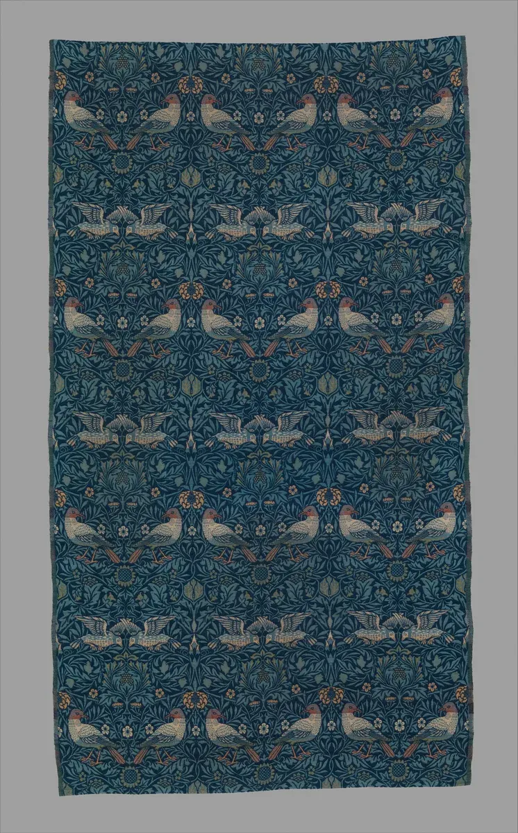 Woven textile of pairs of birds among blue leaves and branches