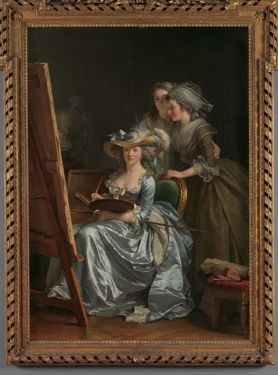 A painter in a silk dress sits at her easel while two young women stand behind her