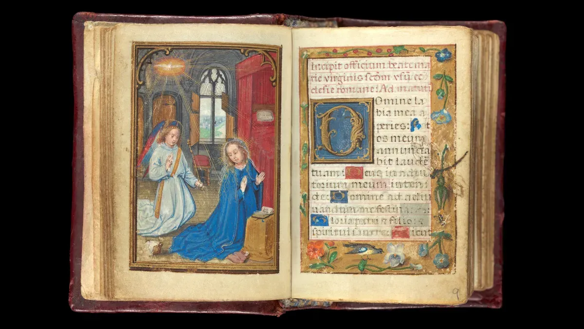 Open book of hours with the Annunciation on the left and a flower border on the right