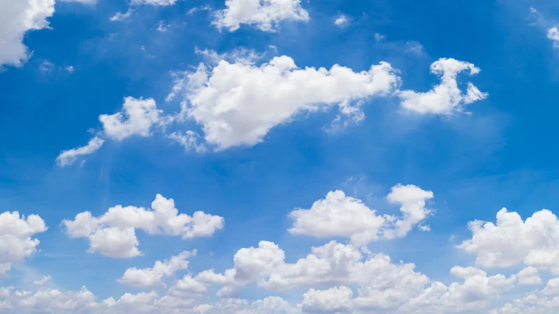 Clouds moving across a clear blue sky, representing the air element